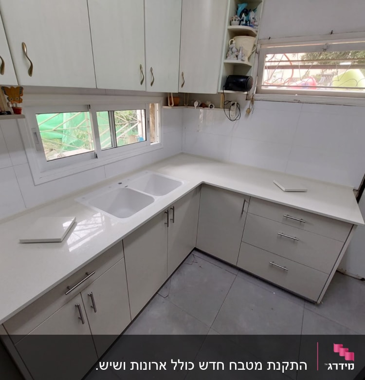 מטבח עם ארונות לבנים וכיור כפול